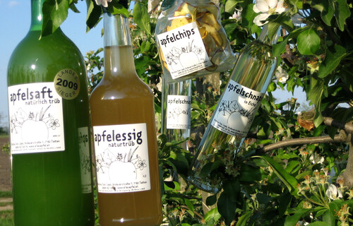 Flaschen mit verschiedenen Apfelprodukten hängen an Apfelbaum | © Alles Apfel