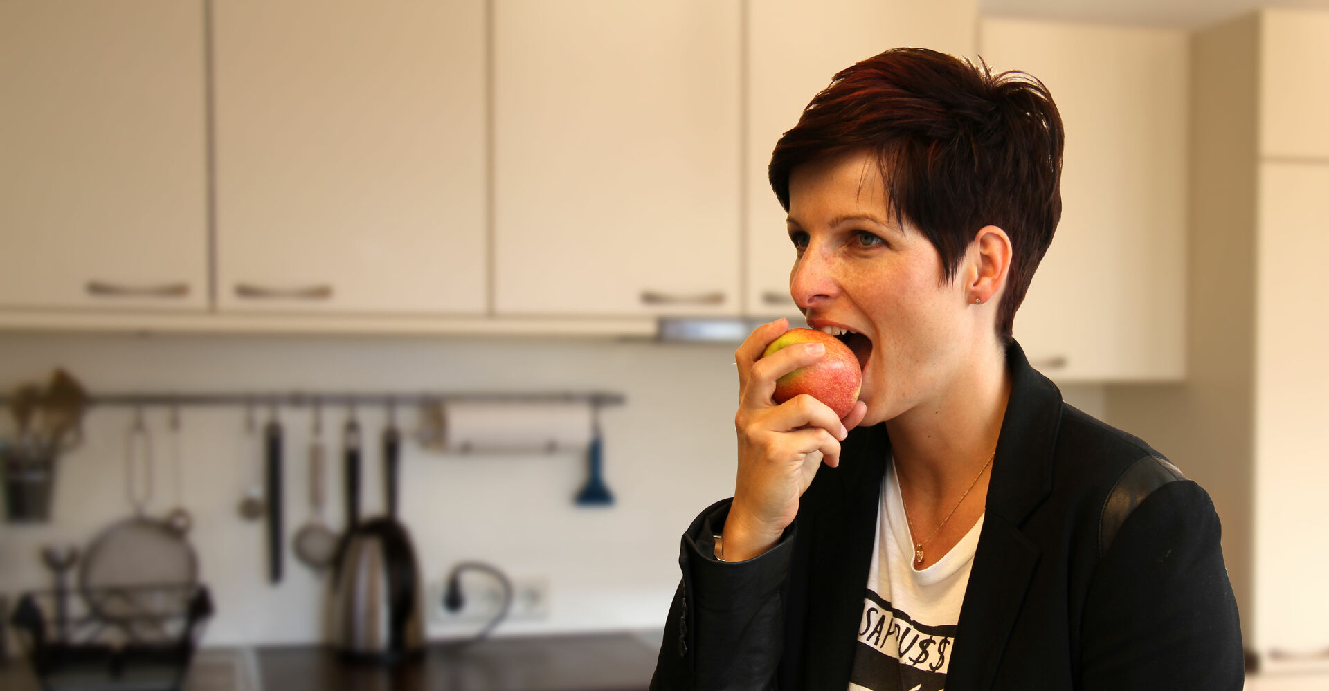 Kurzhaarige Frau beißt in Apfel | © Land schafft Leben