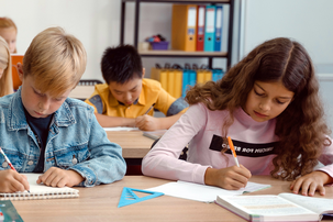 Schülerinnen und Schüler sitzen in einer Klasse