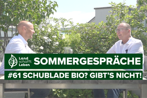 Hannes Royer und Urs Niggli am Terrassentisch um Garten | © Land schafft Leben