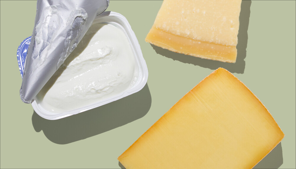 Proteinquellen mit Kalzium als Hauptnährstoff: Eine offene Packung Quark und zwei Stück Hartkäse auf einem grünen Hintergrund. | © Land schafft Leben
