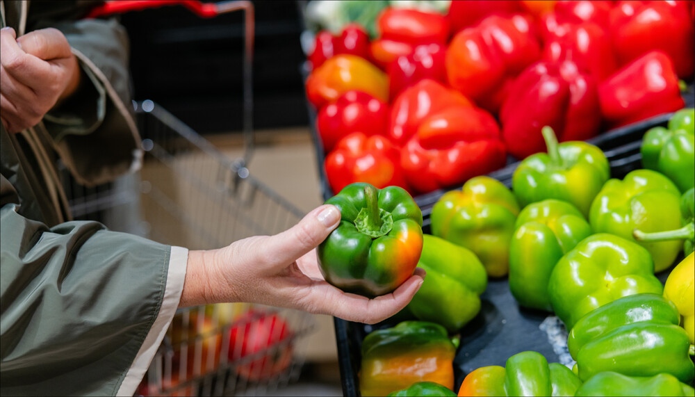 Saisonales Gemüse: Eine Frau hält einen Paprika in der Hand im Supermarkt. | © Land schafft Leben