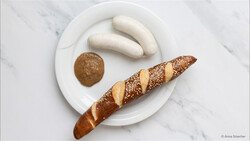 Weißwurst auf Teller mit Senf und Laugenstangerl | © © Anna Stoecher