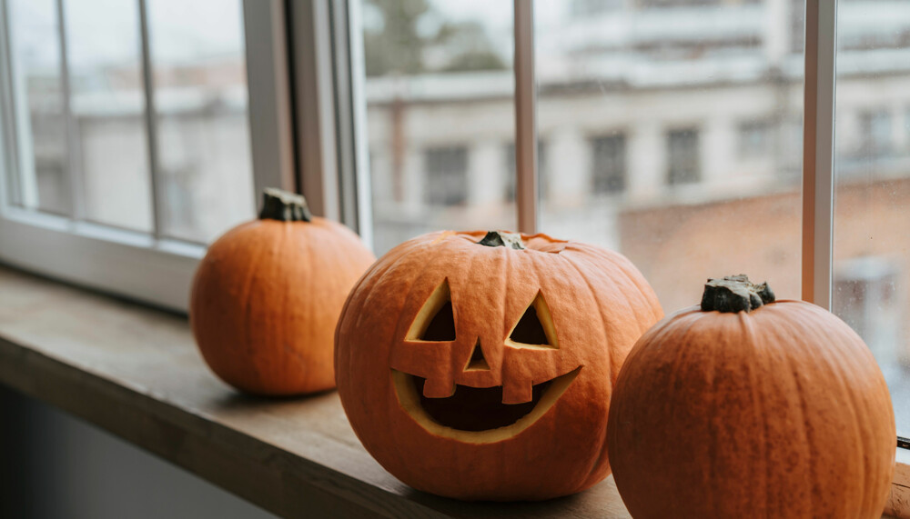 geschnitzte Halloween-Kuerbisse am Fenster | © Pexels
