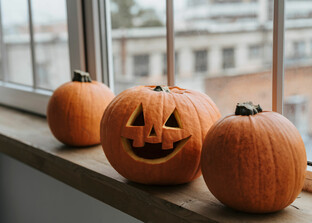 geschnitzte Halloween-Kuerbisse am Fenster | © Pexels