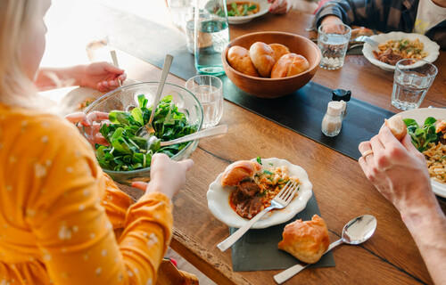 Essen und Psyche | © Land schafft Leben Familie mit Kindern sitzt am Esstisch und teilt Essen auf | © Land schafft Leben
