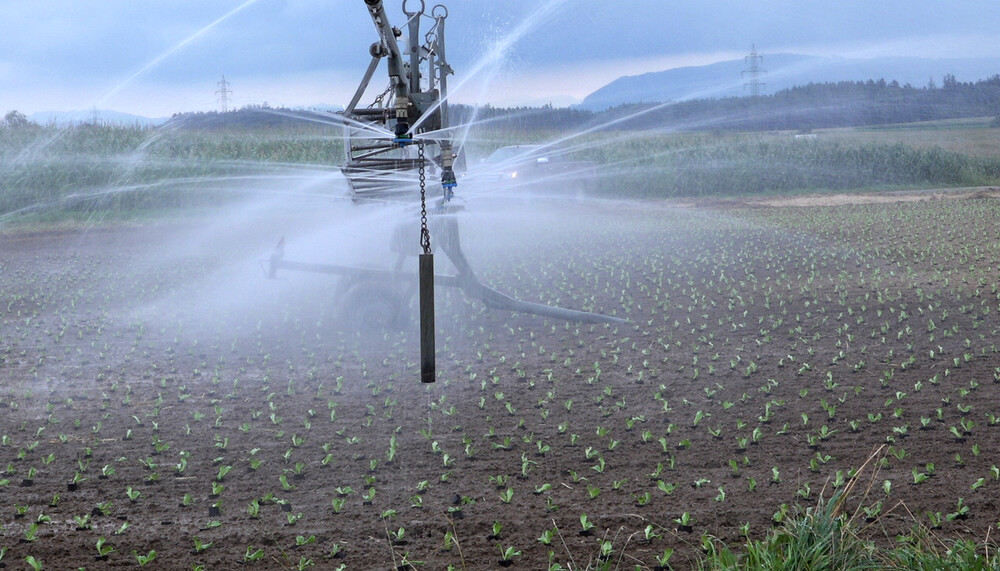 Traktor auf Feld am Bewässern | © Land schafft Leben