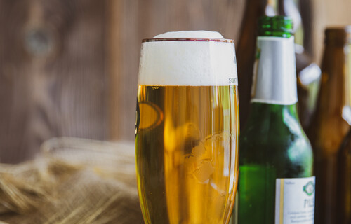 Volles Bierglas neben grüner Bierflasche | © Land schafft Leben