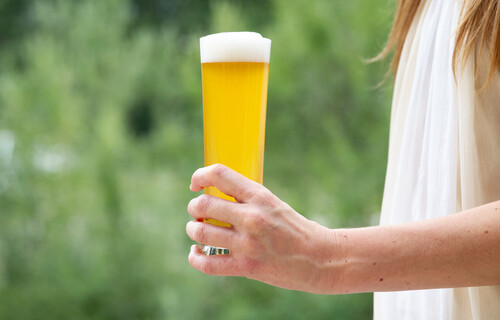 Frau hält volles Bierglas in linker Hand | © Land schafft Leben