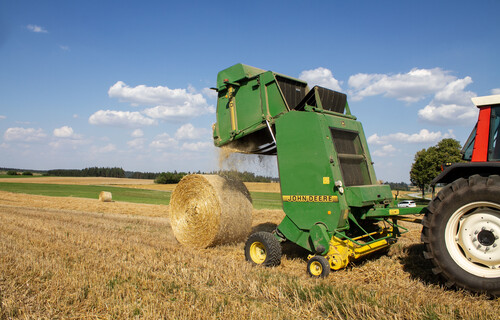 Maschine formt Strohballen auf Feld | © Land schafft Leben