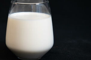 Ein Glas Milch mit schwarzem Hintergrund | © Land schafft Leben