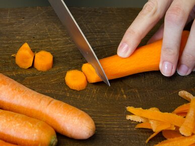 Person schneidet Karotten in kleine Scheiben | © Land schafft Leben