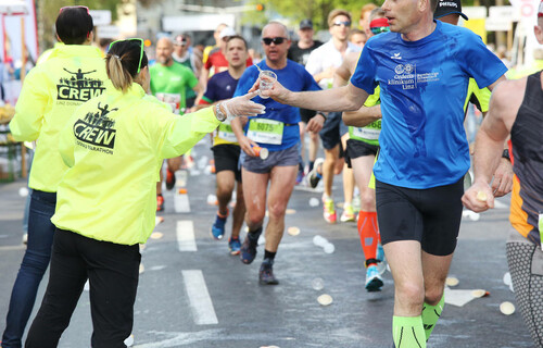 Marathonläufer | © Linz Marathon / Klaus Mitterhauser Frau gibt Marathonläufer Wasserbecher | © Linz Marathon / Klaus Mitterhauser