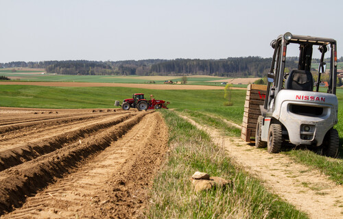 Saatkartoffeln | © Land schafft Leben Gabelstapler steht neben Feld | © Land schafft Leben