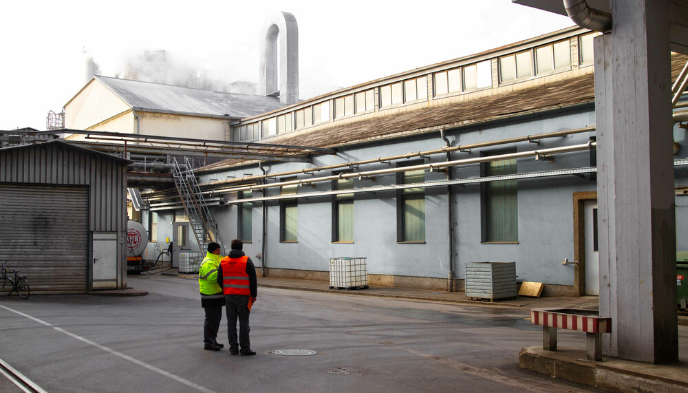 Zwei Personen außerhalb von Fabriksgebäude | © Land schafft Leben