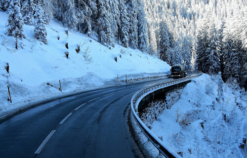 Lastwagen auf Bergstraße umgeben von Schnee