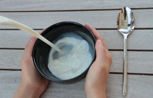 Hände halten Schüssel mit Milch