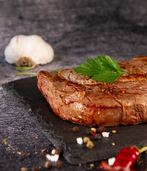 Rindersteak gebraten auf Teller mit Knoblauch und Petersilie | © Land schafft Leben