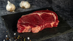 Rohes Rinder Steak Ribeye auf schwarzer Platte | © Land schafft Leben