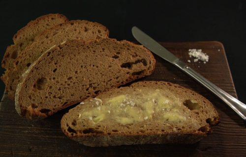 Mehrere Brotscheiben, eine mit aufgestrichener Butter | © Land schafft Leben