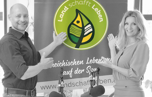 Maria Fanninger und Hannes Royer | © Land schafft Leben Maria Fanninger und Hannes Royer stehen vor einem Land schafft Leben-Plakat | © Land schafft Leben